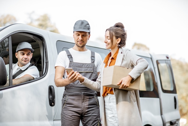 delivery company employees uniform delivering goods client by cargo van vehicle woman signing smartphone receiving parcel outdoors 506452 8